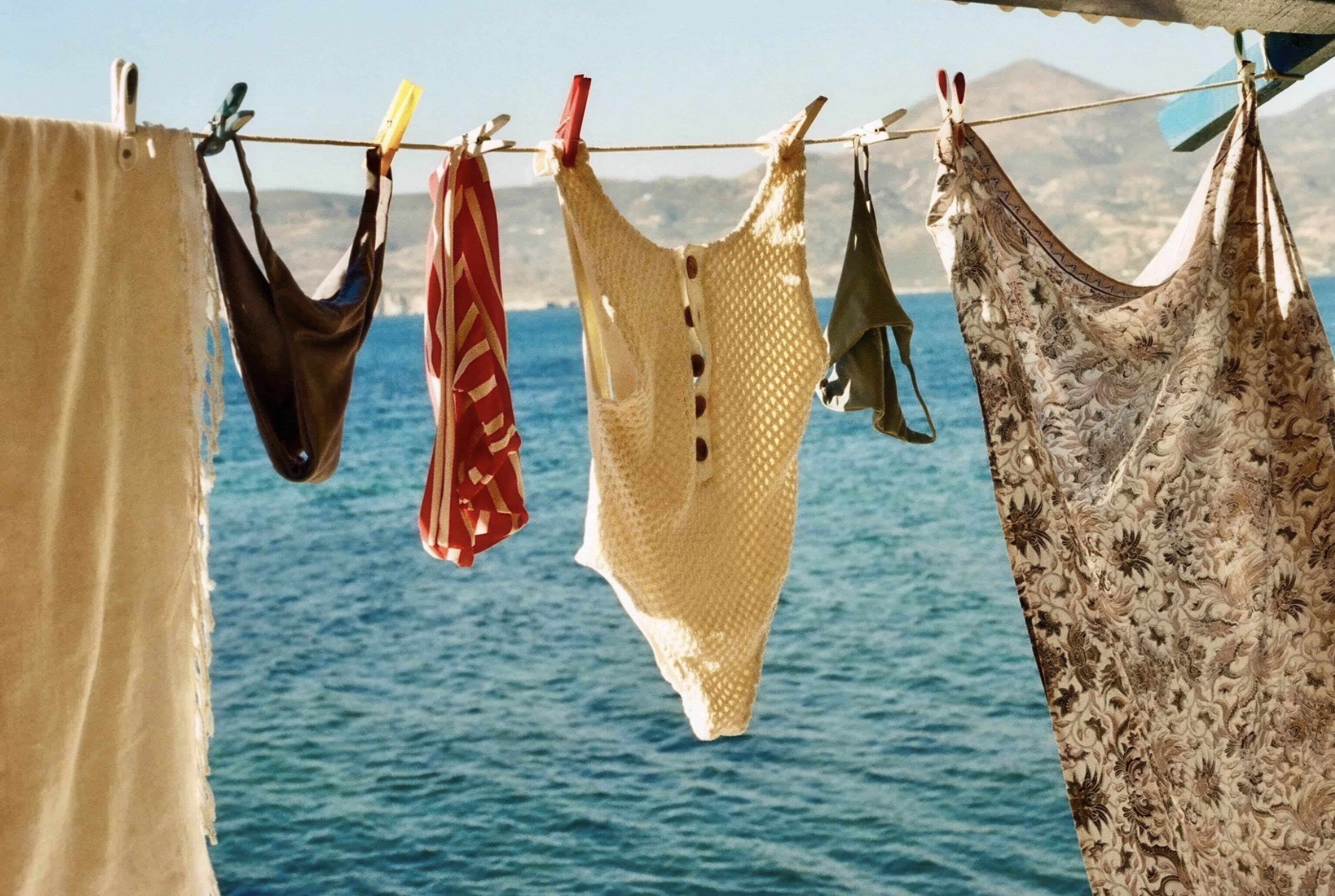 Vintage swimsuits drying on a line above the sea